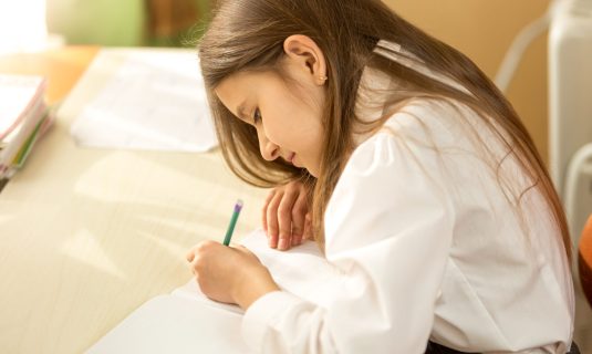 Niña escribe en un cuaderno